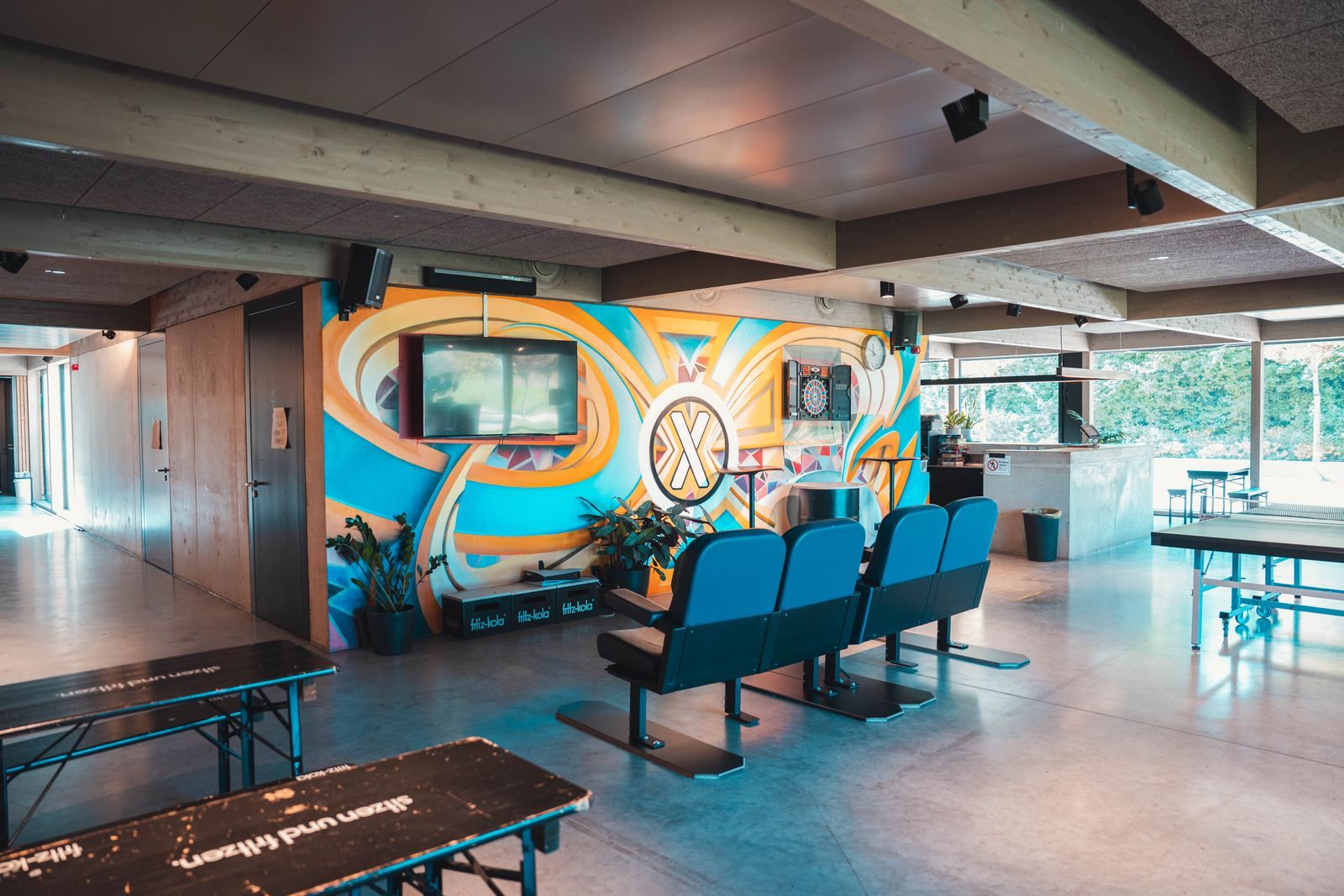 Die Chill-Lounge mit Sitzreihe vor dem X-Wandbild